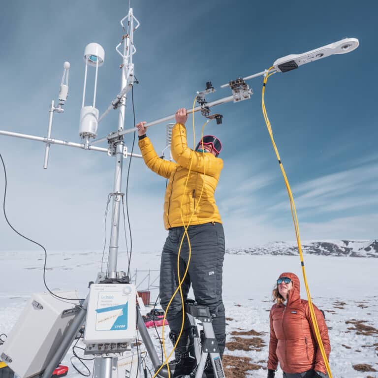 Climate scientists installing field instruments on snow and ice